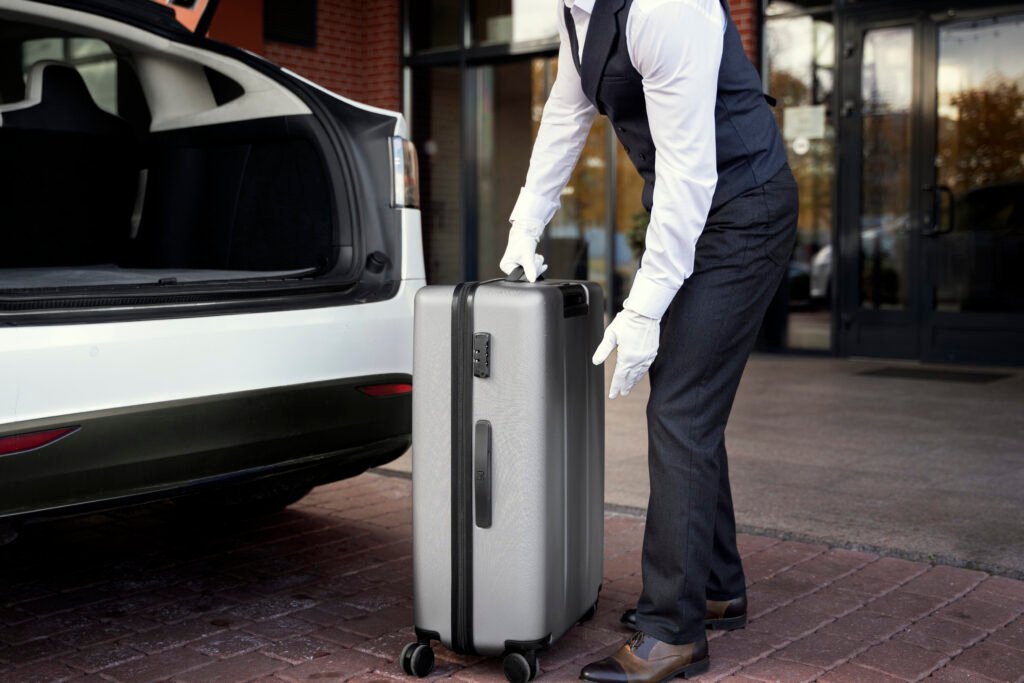 A chauffeur loading luggage into a luxury taxi Chauffeur assisting with luggage at Disneyland paris